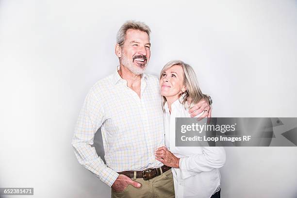 a mature couple posing in a studio looking happy - couple sourire studio photos et images de collection