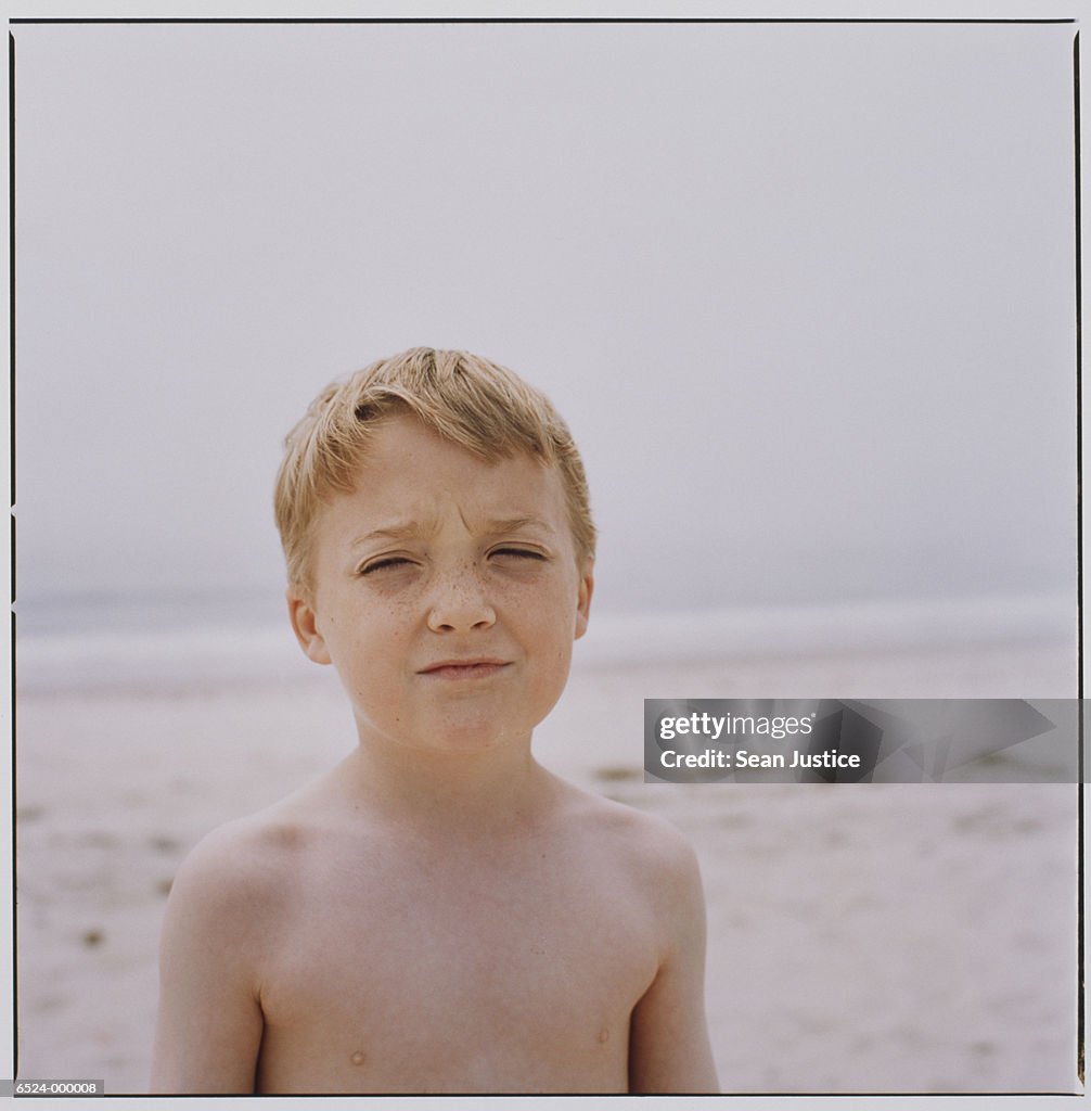 Boy Squinting on Beach