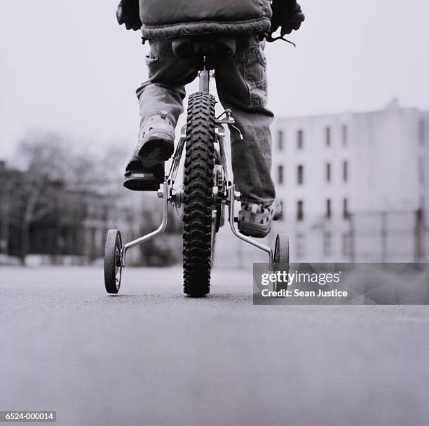 boy on bicycle with stabilizer - stützrad stock-fotos und bilder