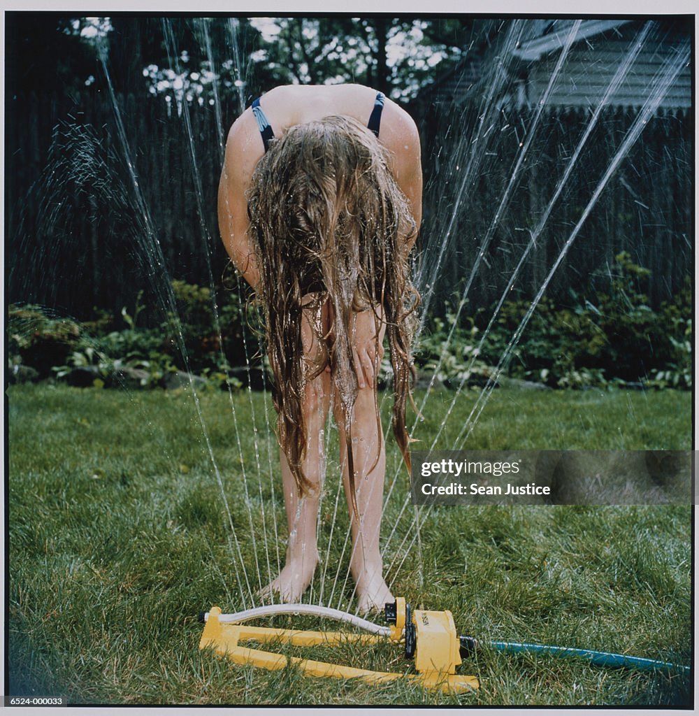 Girl Wetting Hair in Sprinkler