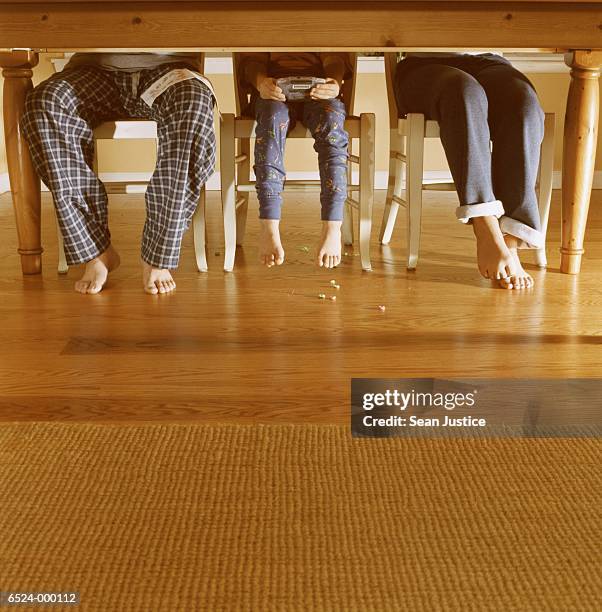 father and children at table - legs on the table foto e immagini stock