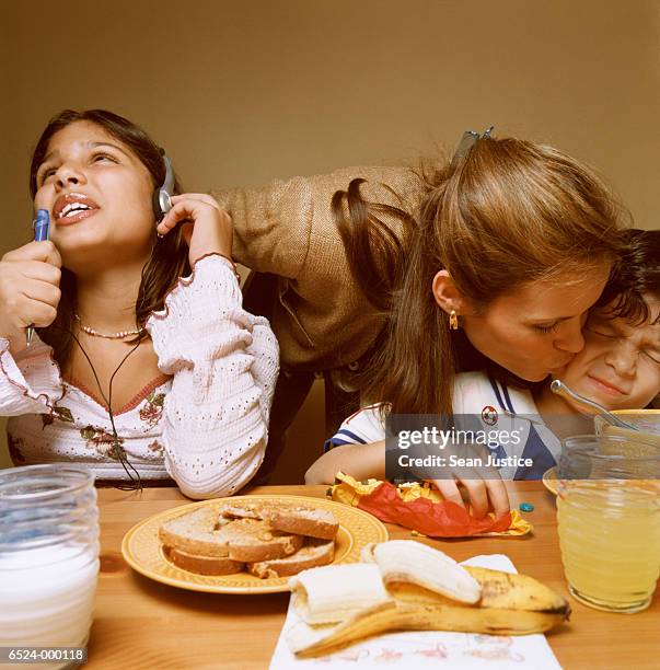 mother kisses children goodbye - breakfast table stock pictures, royalty-free photos & images