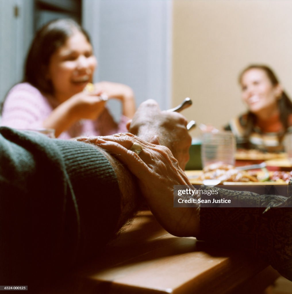 Hand Rests on Arm at Dinner