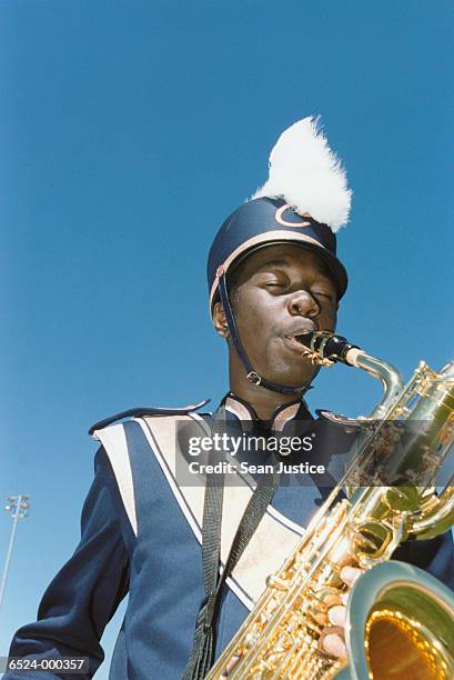 boy playing saxophone - banda de marcha fotografías e imágenes de stock