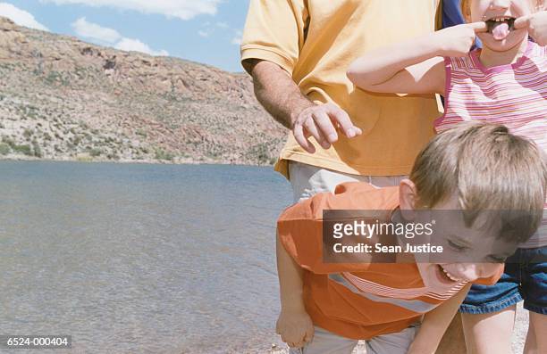 father and children playing - bukken stockfoto's en -beelden