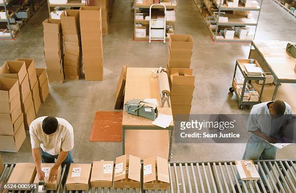 warehouse workers near boxes - boxes conveyor belt stock pictures, royalty-free photos & images