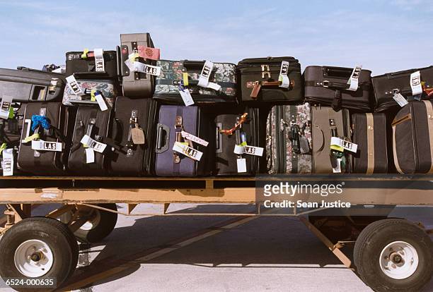 suitcases on luggage cart - hand luggage stock pictures, royalty-free photos & images