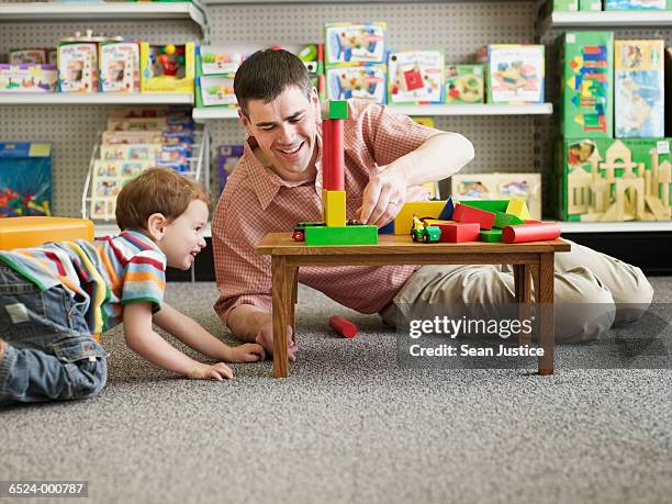 father and son playing - leksaksaffär bildbanksfoton och bilder