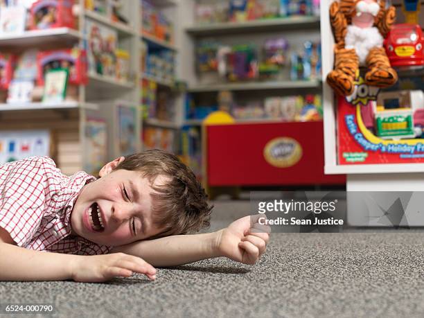 boy crying in toy store - loja de brinquedos imagens e fotografias de stock
