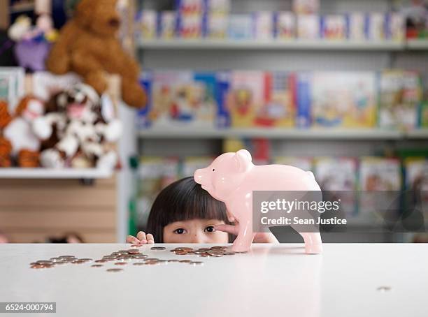 girl with savings in toy store - toy store stock pictures, royalty-free photos & images