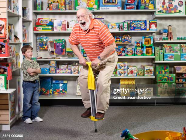 grandfather using pogo stick - top peça de roupa imagens e fotografias de stock