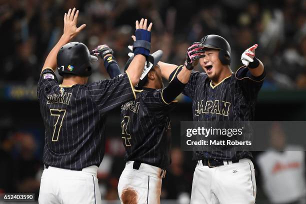 Infielder Sho Nakata of Japan celebrates with Outfielder Norichika Aoki and Infielder Ryosuke Kikuchi after hitting a three-run homerun in the top of...