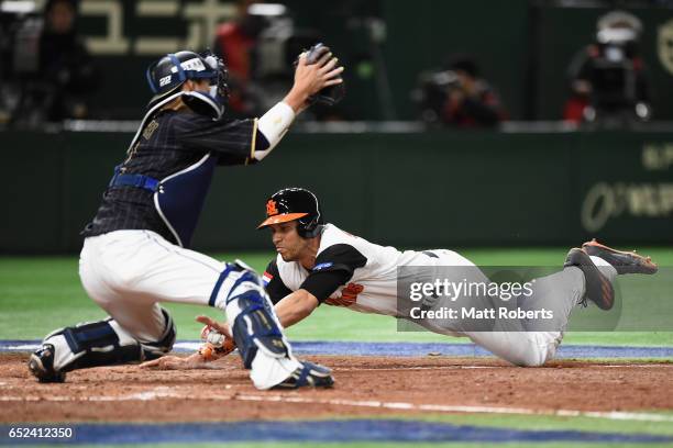 Infielder Andrelton Simmons of the Netherlands slides to the home plate to score a run by a sacrifice fly of Infielder Xander Bogaerts to make it 5-3...