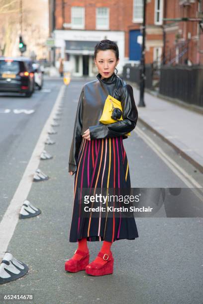 Fashion buyer Jeannie Lee wears Prada shoes, Alice Temperley dress, Zara jacket and J.W Anderson bag on day 2 of London Womens Fashion Week...