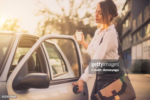 bussines woman getting into car - coffee car design stock pictures, royalty-free photos & images