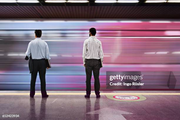 passengers looking at subway train entering the station at high speed - 通勤電車 ストックフォトと画像