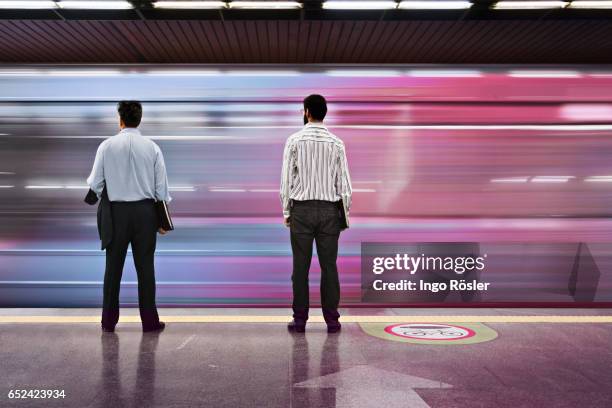 passengers looking at subway train entering the station at high speed - commuter train stock pictures, royalty-free photos & images