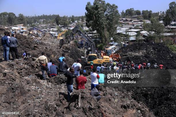 Rescue workers search for those buried by a landslide that swept through a massive garbage dump, killing at least 10 people and leaving several...