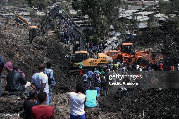 Rescue workers search for those buried by a landslide that swept through a massive garbage dump, killing at least 10 people and leaving several...