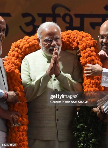 Indian Prime Minister Narendra Modi is greeted on stage at the Bharatiya Janata Party headquarters where he delivered a victory speech in New Delhi...