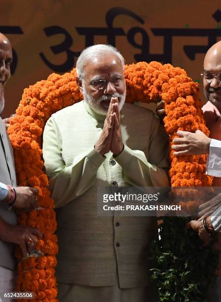 Indian Prime Minister Narendra Modi is greeted on stage at the Bharatiya Janata Party headquarters where he delivered a victory speech in New Delhi...