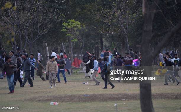 Pakistani kite flyers run from police at a park in Islamabad on March 12 during the Basant Kite Festival which is traditionally celebrated in spring...