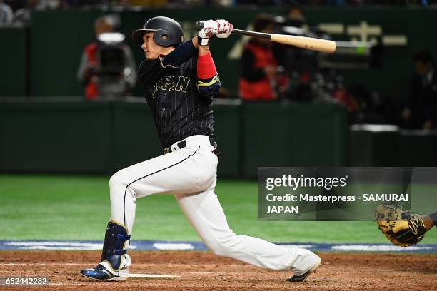 Infielder Hayato Sakamoto of Japan hits a single in the top of the ninth inning during the World Baseball Classic Pool E Game Two between Japan and...