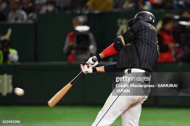 Infielder Hayato Sakamoto of Japan hits a single in the top of the ninth inning during the World Baseball Classic Pool E Game Two between Japan and...