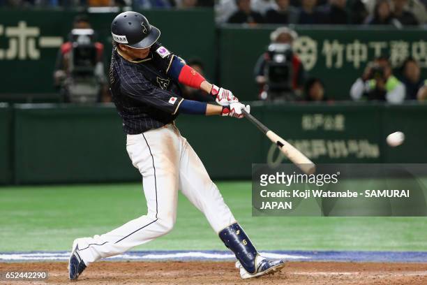 Infielder Hayato Sakamoto of Japan hits a single in the top of the ninth inning during the World Baseball Classic Pool E Game Two between Japan and...