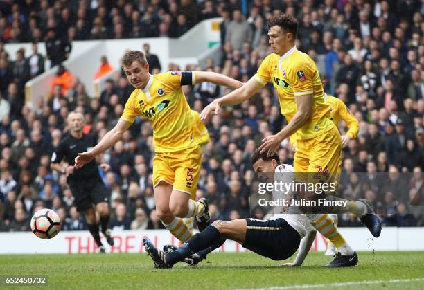 Tony Craig of Millwall and Jake Cooper of Millwall challenge Dele Alli of Tottenham Hotspur during The Emirates FA Cup Quarter-Final match between...