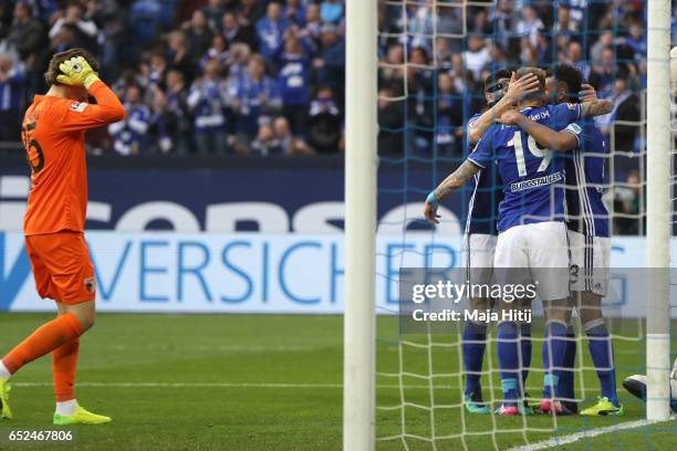 Marwin Hitz , keeper of Ausgburg reacts whilst Guido Burgstaller of Schalke celebrates scoring the second team goal with his team mates during the...