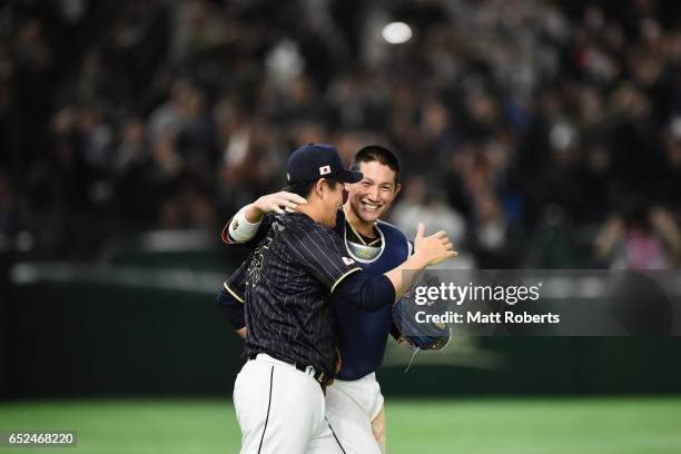 Pitcher Kazuhisa Makita and Catcher Seiji Kobayashi of Japan celebrate their 8-6 victory after the World Baseball Classic Pool E Game Two between...