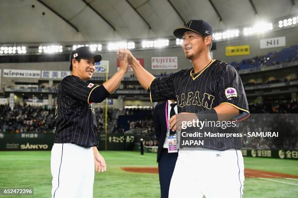 Pitcher Kazuhisa Makita and Infielder Sho Nakata of Japan celebrate their victory after the World Baseball Classic Pool E Game Two between Japan and...