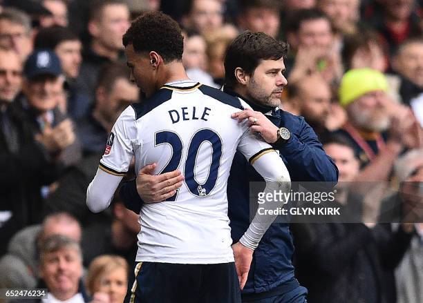 Tottenham Hotspur's Argentinian head coach Mauricio Pochettino congratulates Tottenham Hotspur's English midfielder Dele Alli as he is substituted...