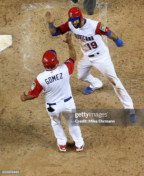 Jose Bautista of the Dominican Republic is congratulated after scoring on a three run home run by Nelson Cruz during the eighth inning during a Pool...