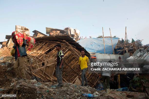 People move their belongings on March 12, 2017 after dwellings built near the main landfill of Addis Ababa on the outskirts of the city were damaged...