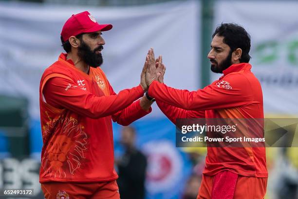 Saeed Ajmal of HKI United celebrates with teammate Misbah Ul-Haq of HKI United after taking the wicket during the Hong Kong T20 Blitz match between...