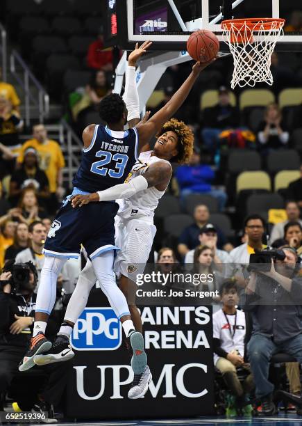 Kuran Iverson of the Rhode Island Rams goes up for a shot against Justin Tillman of the Virginia Commonwealth Rams during the championship game of...