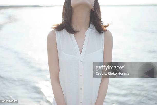 woman standing on the beach - sleeveless ストックフォトと画像