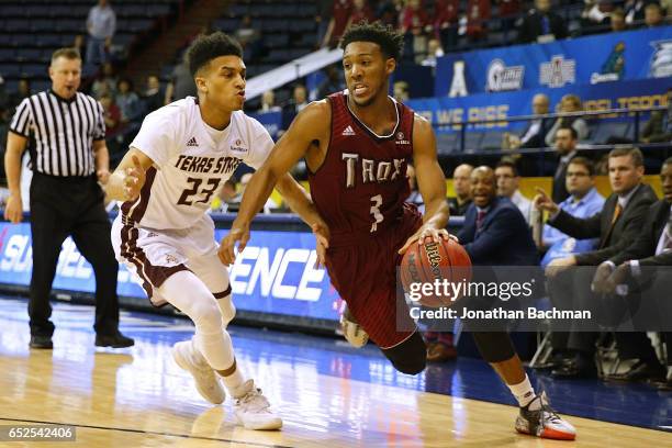 Wesley Person of the Troy Trojans drives against Marlin Davis of the Texas State Bobcats during the first half of a game in the final round of the...