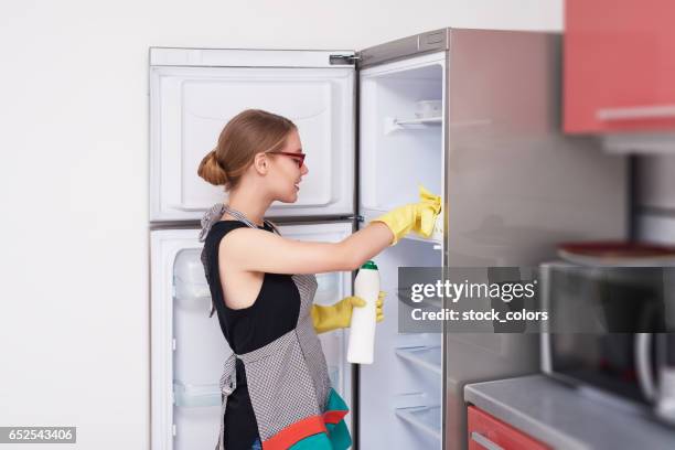 sidovy av kvinna rengöring kylen - washing up glove bildbanksfoton och bilder