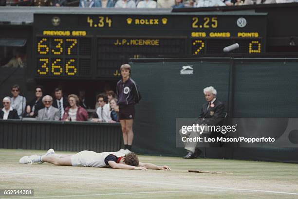 American tennis player John McEnroe pictured lying face down on the court during the final of the Men's Singles tournament before losing to Jimmy...