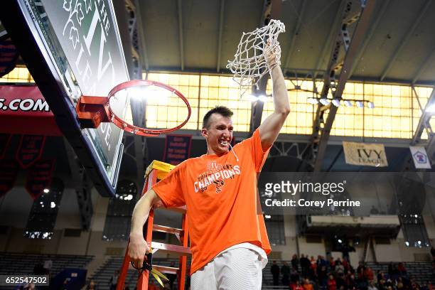 Steven Cook of the Princeton Tigers is the last to cut down the whole net after the win against the Yale Bulldogs in the Ivy League tournament final...