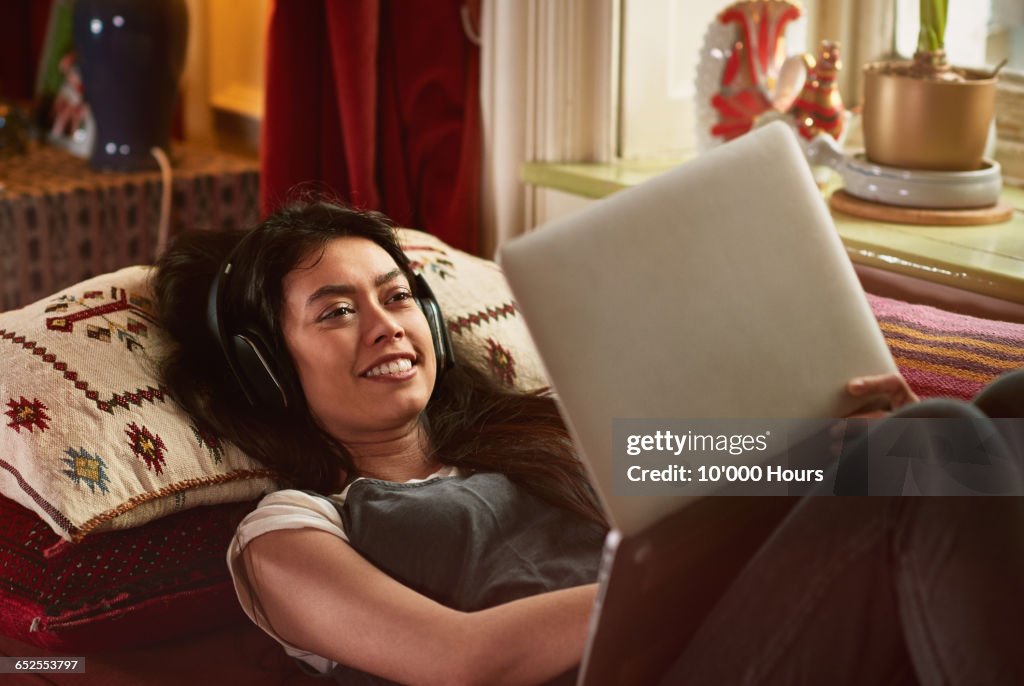 Young woman watching a film on her laptop