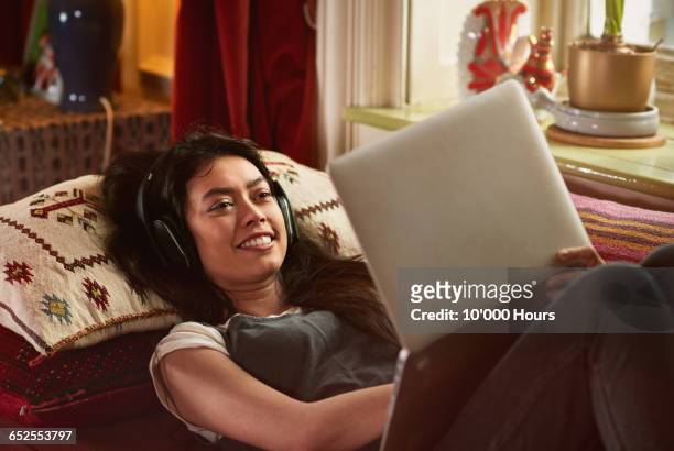 young woman watching a film on her laptop - berkshire england stock pictures, royalty-free photos & images