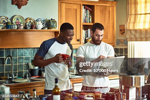 Two flatmates looking at something on a laptop Two flatmates looking at something on a laptop