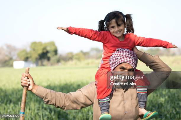 father carrying daughter on shoulders - turban family stock pictures, royalty-free photos & images