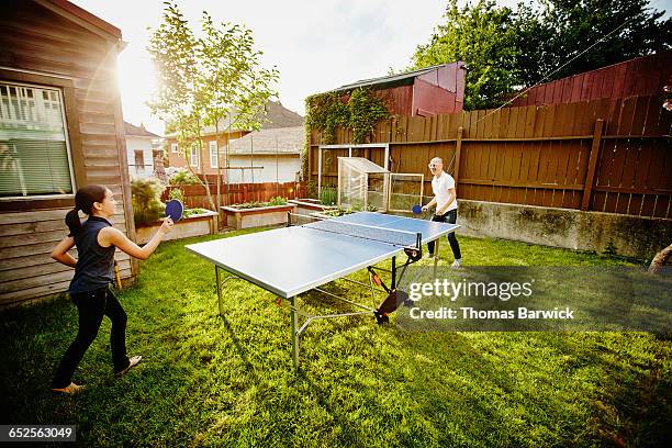 young daughter and father playing ping pong - men's table tennis stock pictures, royalty-free photos & images