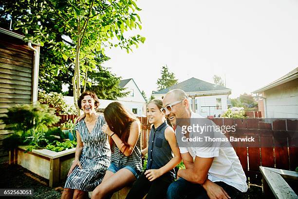 Laughing family sitting together in garden of home