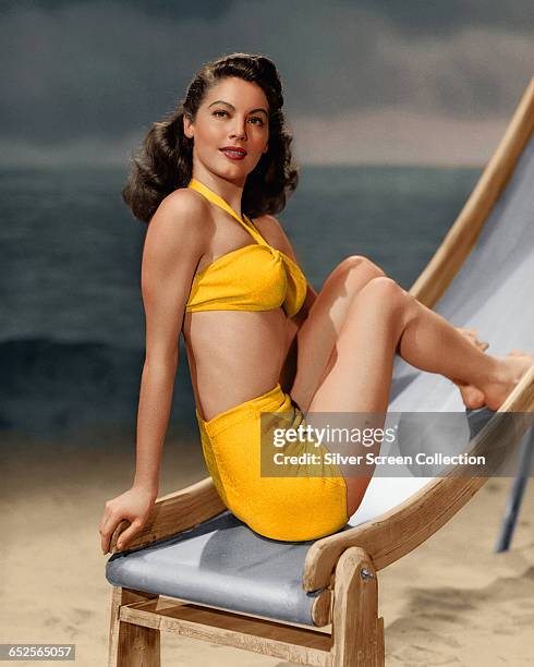 American actress Ava Gardner poses on a deckchair wearing yellow bikini, circa 1945.